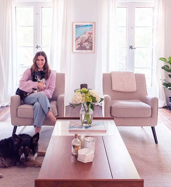 Image of Caption: Sarah Levy sat down on the couch in her home with her two dogs 