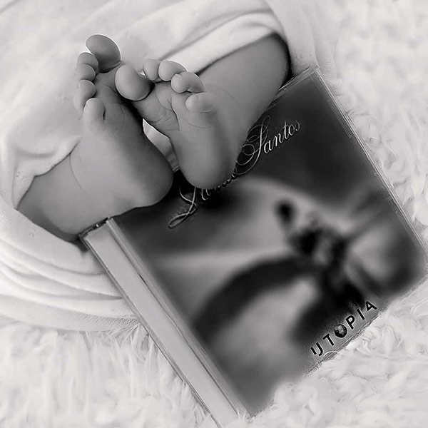 Image of Caption: Romeo Santos posted a black and white photo, which showed his newborn baby's feet resting on the top of his fourth album Utopia.